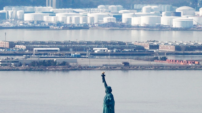 Oil Prices statue of liberty with oil storage facility